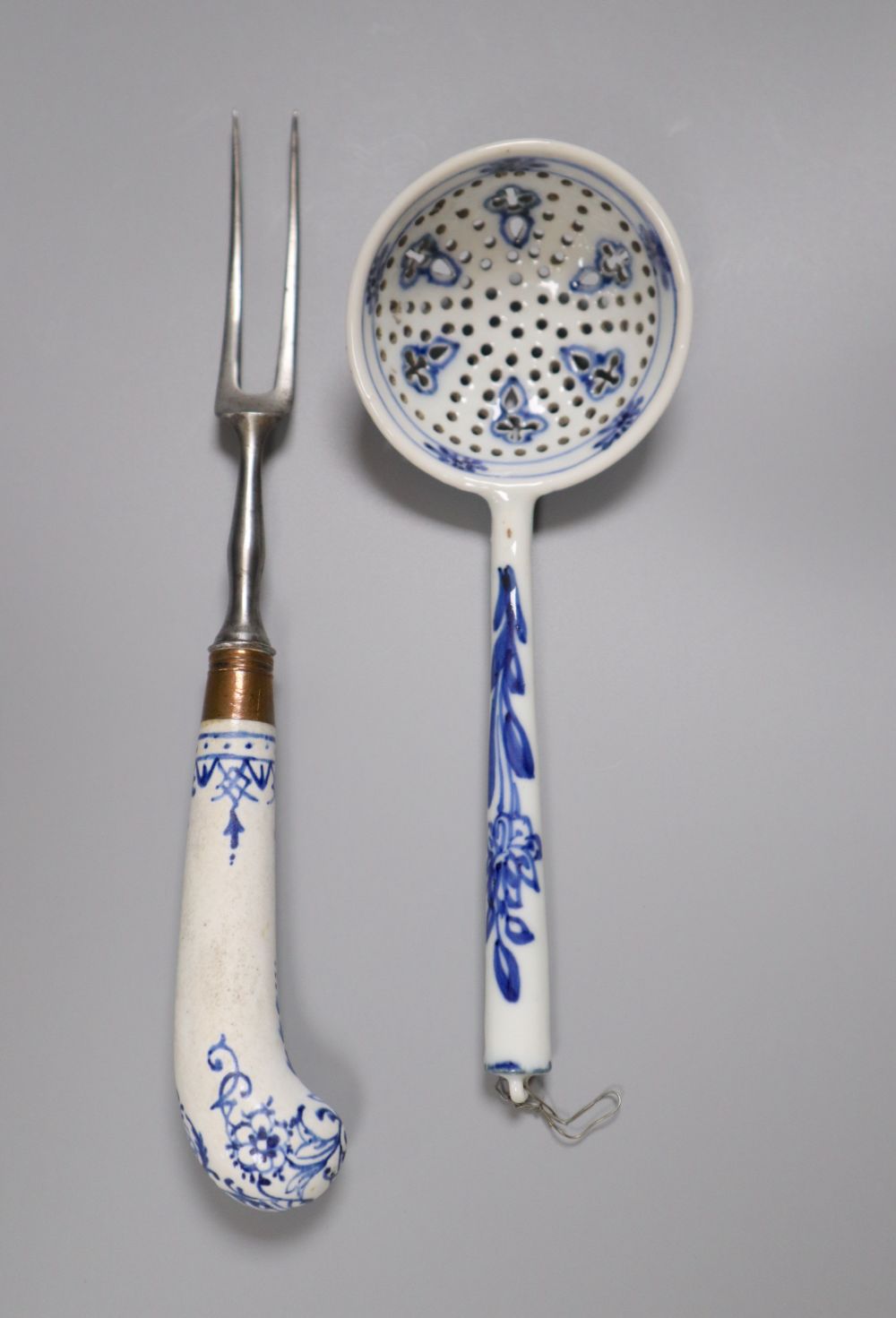 A Bow pistol grip blue and white handled fork, c.1770, 23cm, and a Continental porcelain blue and white strainer ladle, 17cm